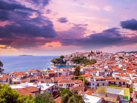 Sunset over Skiathos town on Skiathos Island, Greece. Beautiful view of the old town with boats in the harbor.の写真素材