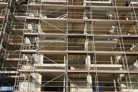 Scaffolding on a construction of a residential building filling the whole photo as background.のeditorial素材