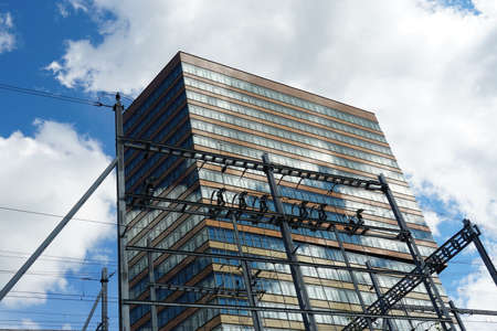 Modern office building near a train station the contact line and their supporting frames are in the...