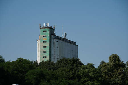 Old industrial building in a provincial town in Eastern Europe with aerials and antennas places on the rooftop enabling better signal intake and spreading.のeditorial素材