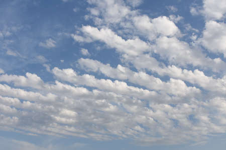 Azure blue sky with white cirrocumulus and alto cumulus	woolpacks or heap clouds during sunny summer...