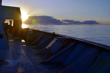 Sunset on the Atlantic ocean taken from the cargo container ship from forward manoeuvring station. Sunrays are dispersed by the edge of windbreaker on forecastle of the vessel.の写真素材