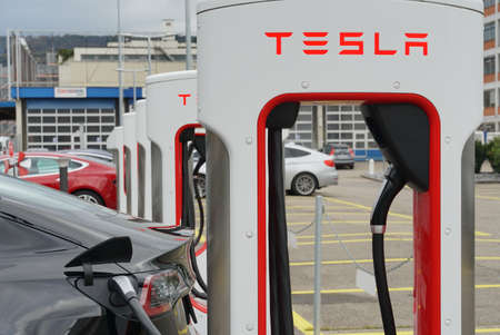 Tesla electric charging stations arranged in a row. They are located in an industrial zone on the...