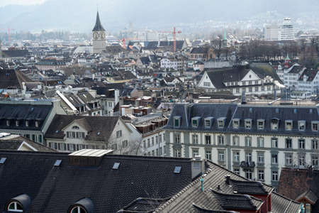 Zurich, Switzerland - 03 12 2020: Panorama of Zurich historical center. Tower of St. Peter Church, evangelical reformed, is on the background above the rooftops. Panoramic view in the old city.のeditorial素材