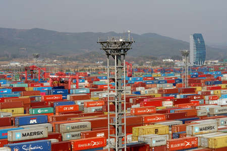 View of the port of Kwangyang , South Korea full of containers in terminal with mountain in...