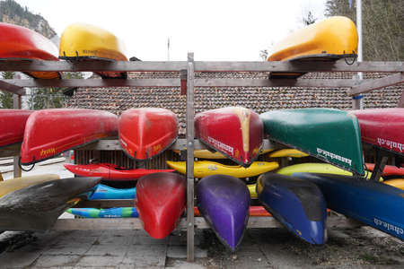 Kayaks and canoes stored in racks upside down in front view. They wait for the start of the water sport season.の写真素材