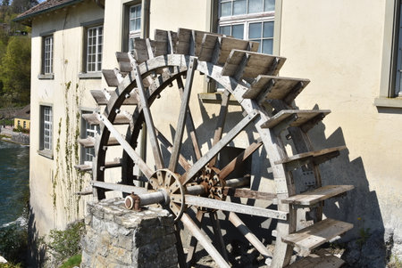 Old wooden water-wheel mill beside house at the Rhine Falls in Schaffhausen.
