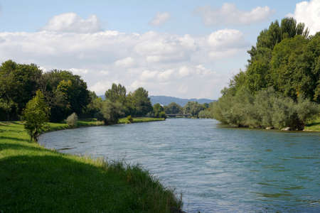 River Limmat in canton Zurich, Switzerland in summertime. There are trees on both banks and a...