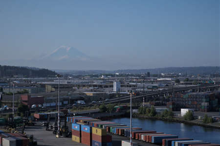 Seattle, USA 07 12 2021: Mount Rainier, also known as Tahoma or Tacoma, is a large active stratovolcano in the Cascade Range of the Pacific Northwest visible from Seattle container terminal in sunset.のeditorial素材