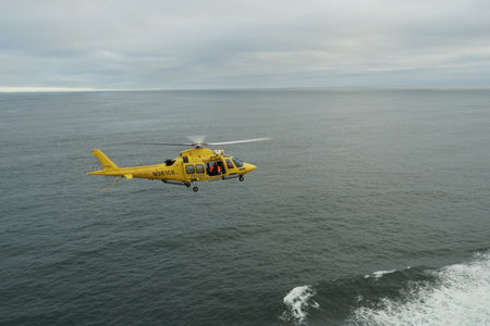 Astoria, USA 07 15 2021: Flying yellow helicopter of Columbia River Bar Pilots ready for embarking...