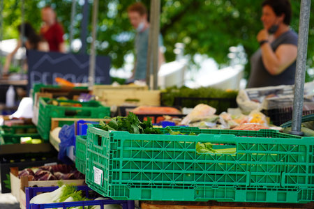 Market stall with vegetables and fruits. There are defocused persons on the background. The...