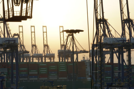 Piraeus, Greece - 04 26 2022: View to silhouette of high construction of big gantry cranes in horizontal position awaiting cargo operation of the container ships in port of Piraeusのeditorial素材