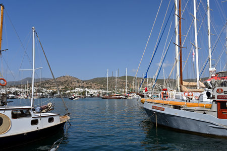 Moored yachts, sailboats and Gulets, traditional boats in Turkey, observed from a main promenade in the port of Bodrum runs alongside the marinaの写真素材