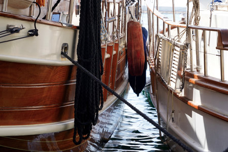 Two luxury sailing boats for tourist with fenders in Turkey are moored side by side, observed from a...