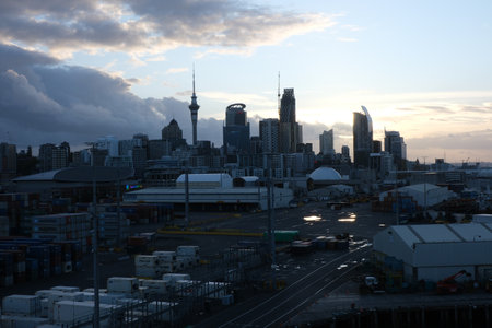 Silhouette of the city of Auckland, New Zealand seen from a container terminal in cargo ship port during sunset.の写真素材