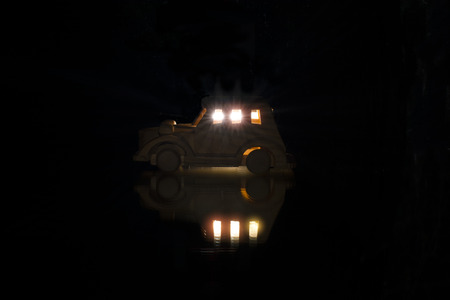 Wood toy car isolated on black backgroundの写真素材