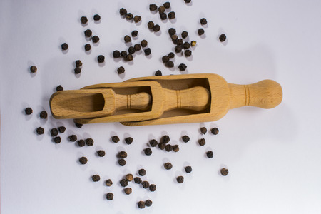 Wooden  scoops and black pepper beansの写真素材