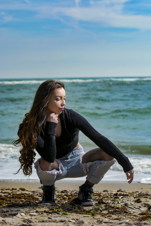 Young woman posing on Black Sea shore in a spring dayの写真素材