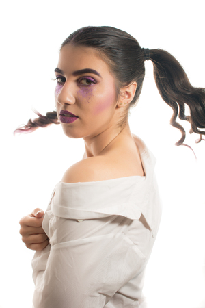 Young girl with two pony tails and artistic make up on  white  backgroundの写真素材