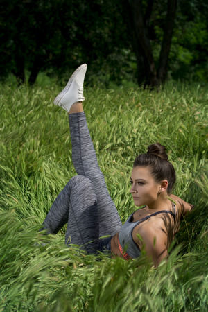 Fit young girl posing for camera during outdoor gym exercisesの写真素材