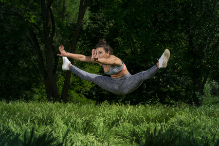 Fit young girl posing for camera during outdoor gym exercisesの写真素材