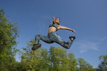 Fit young girl posing for camera during outdoor gym exercisesの写真素材