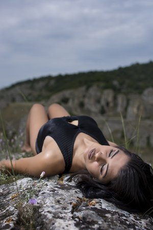 Young girl wearing black bodysuit posing outdoorの写真素材