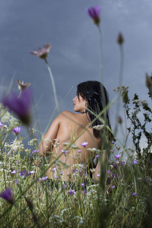 Topless young girl posing in grass fieldの写真素材