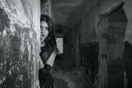 Young girl wearing leather jacket and pants posing in an old buildingの写真素材