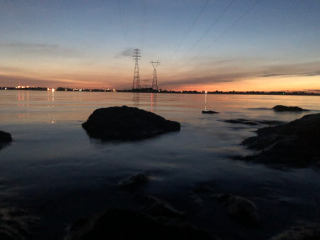 sunset over the river with high voltage electricity pylons and rocks