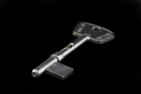 silver blank key isolated on a black backgroundの写真素材