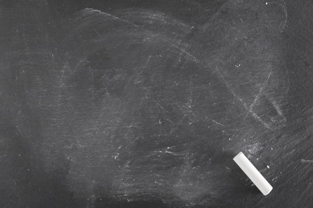 Background of a black board with single piece of chalkの写真素材