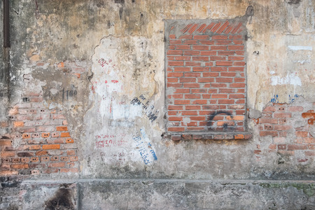 Bricked up window in a weathered old wallの写真素材