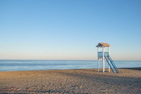 Blue and white life gaurd hut on a beach at sunset.の写真素材