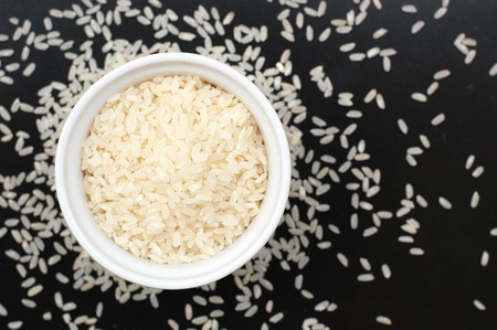 Risotto rice in the bowl on the black background, overhead horizontal viewの写真素材