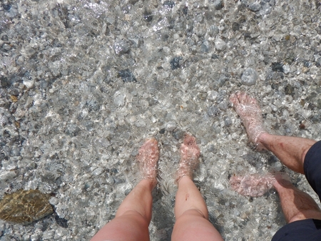 detail of feet of a couple refreshing in a cold riverの写真素材