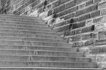 black and white old stone staircase with a block wallの写真素材