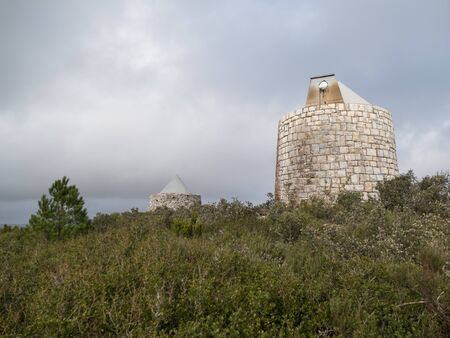 abandoned traditional windmill in a windy landscape in portugal