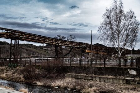 abandoned factory with old pipes by the riverの写真素材
