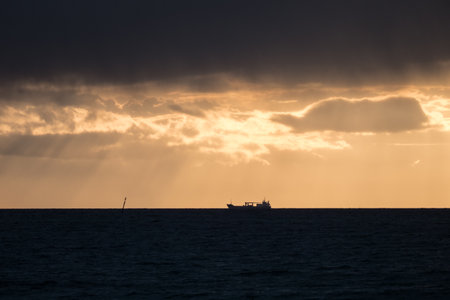 silhouette of a ship in a beautiful colorful sunsetの写真素材