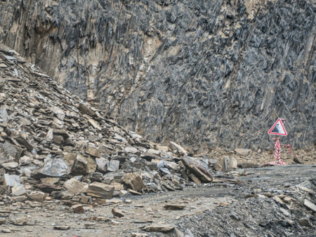 danger stone and rock landslide on a gravel roadの写真素材