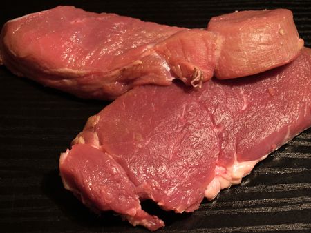 Two big bloody steaks on the wooden board  の写真素材