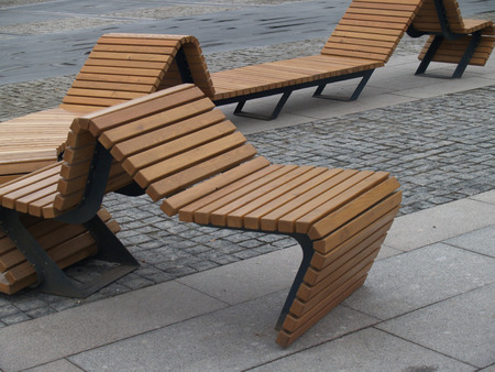 curved design wooden benches on a pavementの写真素材