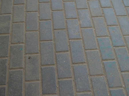 Closeup of a surface of textured tiles of pavementの写真素材