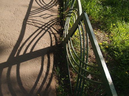 Iron fence, bright sunlight and deep shadow compositionの写真素材