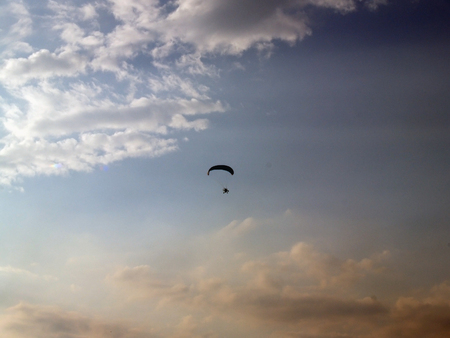 Paraglider against cloudy skyの写真素材