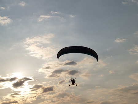 Paraglider against cloudy skyの写真素材