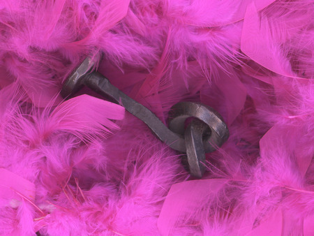 Rusty old iron objects against pink feather backgroundの写真素材