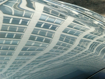 Reflection of an office building in mirror surface of a carの写真素材