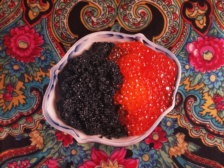 black and red caviar in a traditional porcelain  blue and white dishes on vintage expressive tableclothの写真素材